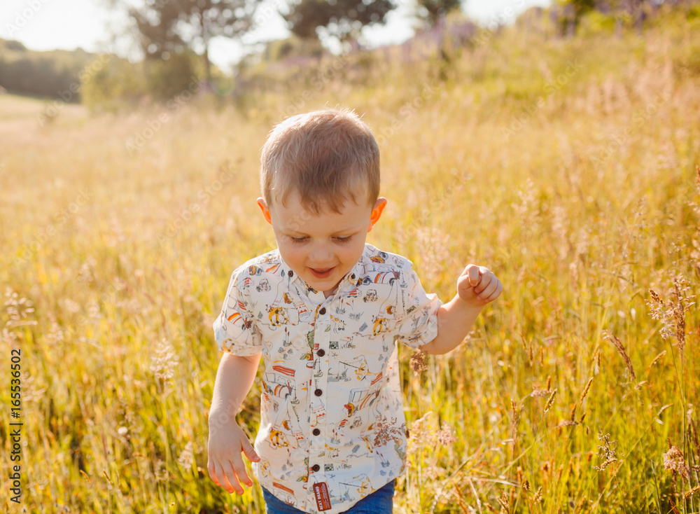 Happy boy runs across the golden field Happy boy runs across the golden field