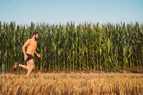 Uomo che corre in un campo di grano in campagna