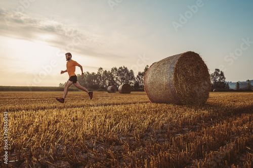 Uomo che corre in un campo di grano in campagna