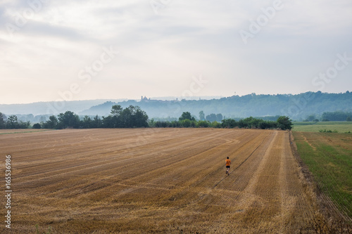 Uomo che corre in un campo di grano in campagna