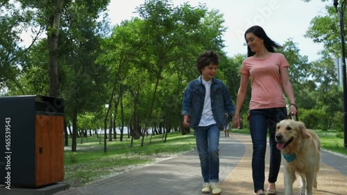 Mother and little son walking with a purebred dog