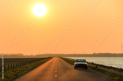 Bilde på lerret Mysterious car on the levee at sunset in the Netherlands