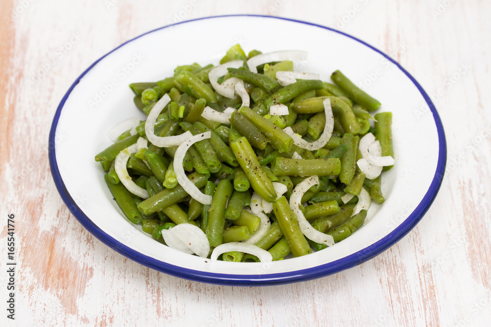 boiled green beans in dish on wooden background