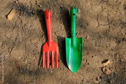 Garden hand fork and shovel lay on the ground