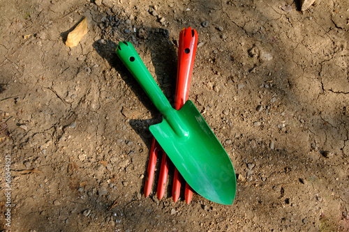 Garden hand fork and shovel lay on the ground
