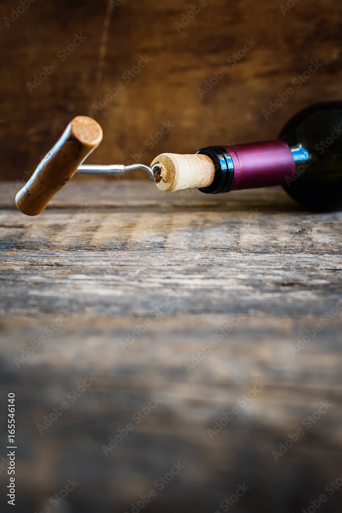 Bottle Wine with Corkscrew on Wooden Background