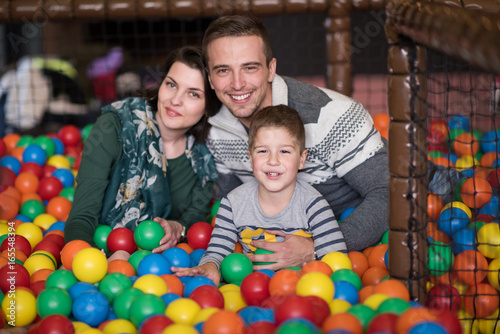 young parents with kids in a children's playroom photo