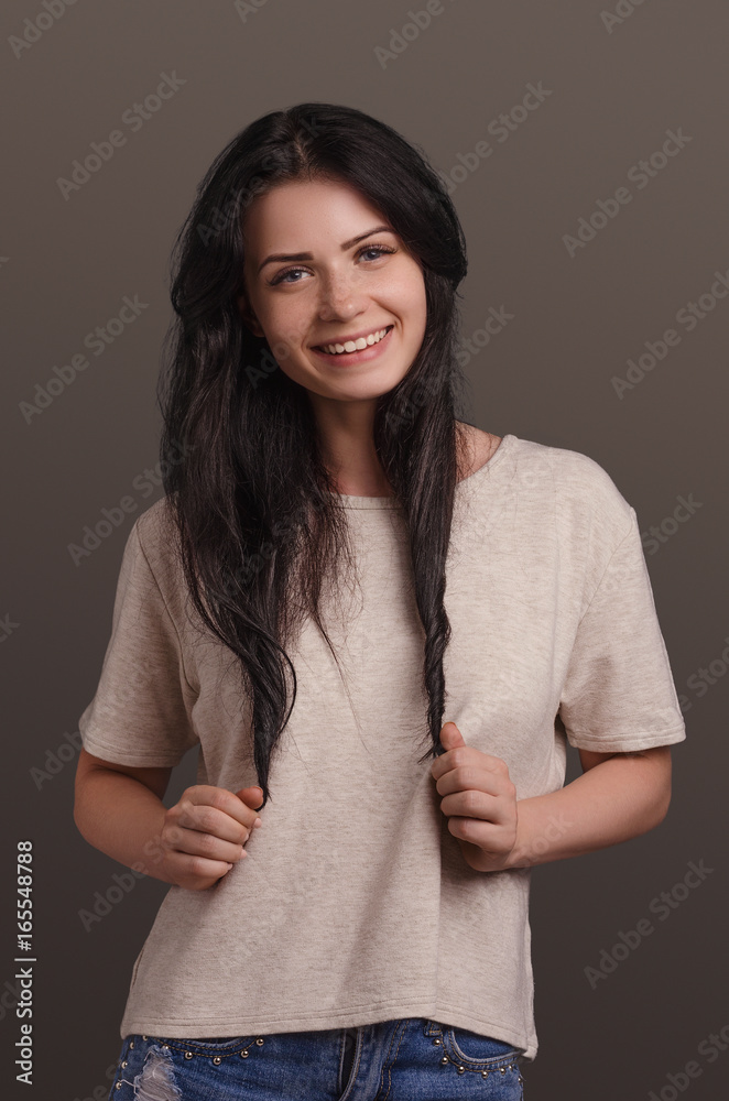 Fototapeta premium Young attractive girl smiling on a brown background. Portrait. Beautiful woman.