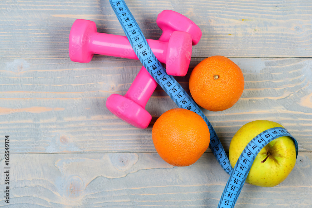 fruits with dumbbells weight and measuring tape on blue vintage fruits with dumbbells weight and measuring tape on blue vintage