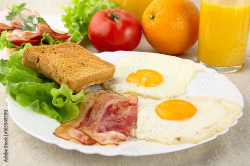 Healthy breakfast with bacon  eggs toast and glass of juice