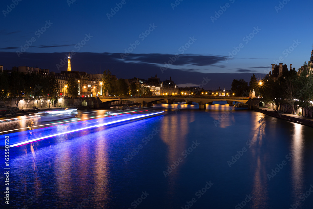 Paris, Night time on river seine, view on Tour Eiffel and boats passing by