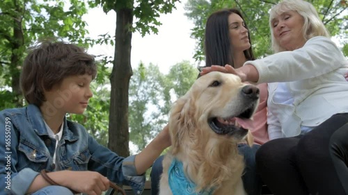 Low angle of a friendly family resting with the dog