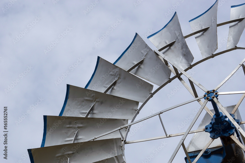 detailed view of silver wind wheel with blades with blue edges