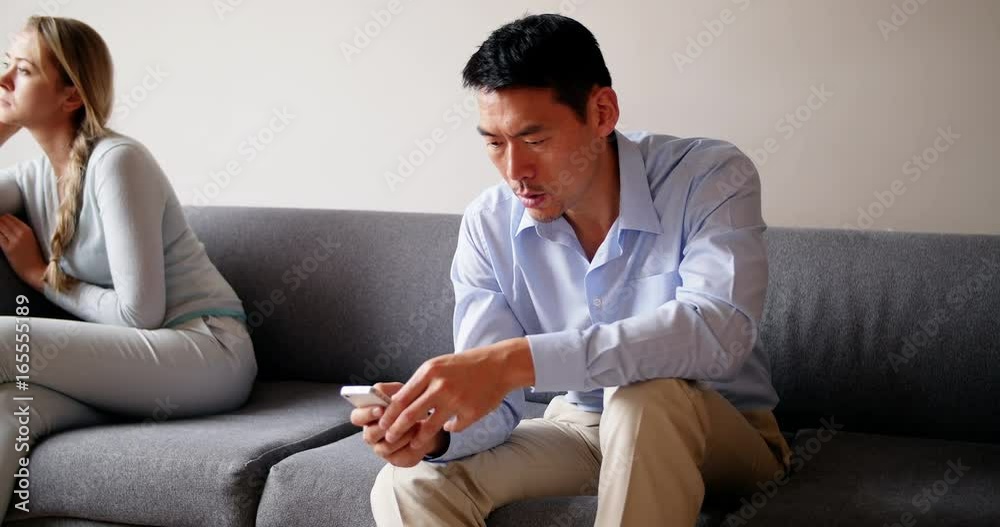 Man using mobile phone while sitting on sofa Man using mobile phone while sitting on sofa