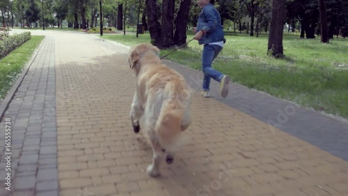 Positive little boy running with his dog