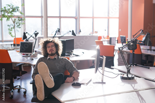 businessman sitting with legs on desk