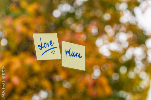 Love mum written in post it note in front of autumn leaves