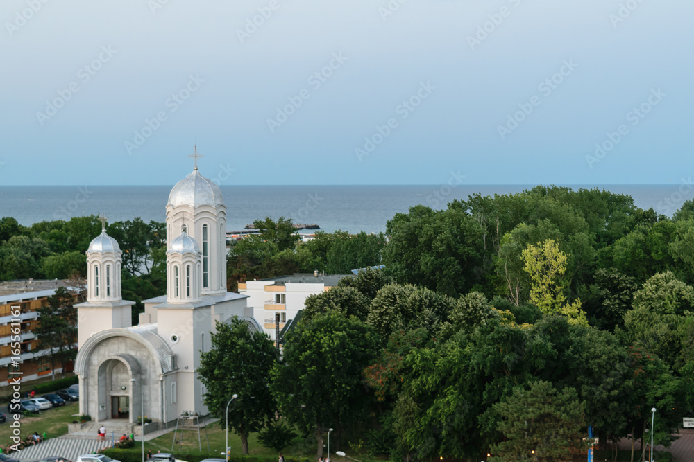Neptun Olimp, Romania - picture showing the local Christian church, green forest and the Black Sea.