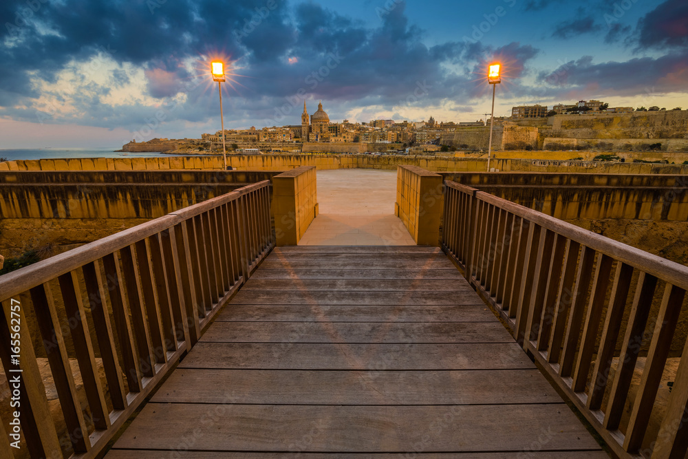 Manoel Island, Malta - Entrance of the beautiful Fort Manoel with St.Paul's Cathedral and Valletta at background at dusk