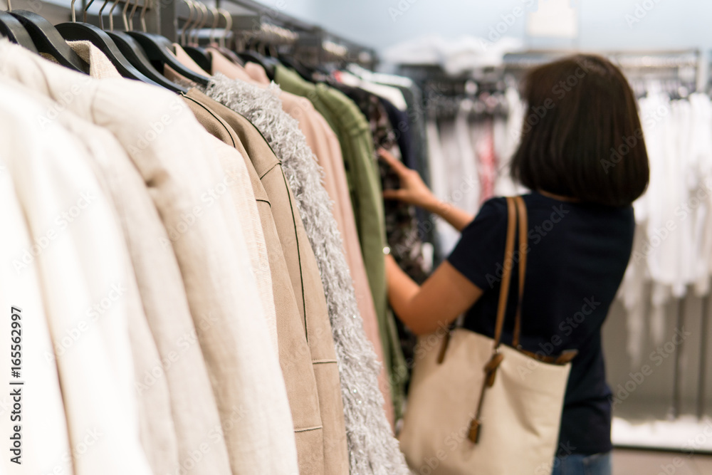 Woman is buying clothes. By ignoring the closet of her home that no to keep clothes again.