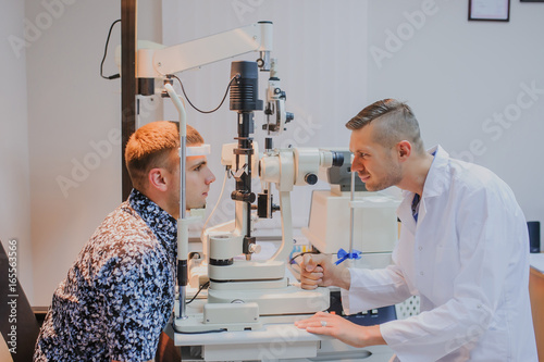 Young beautiful doctor/eye specialist/optometrist in an ophthalmologic clinic photo