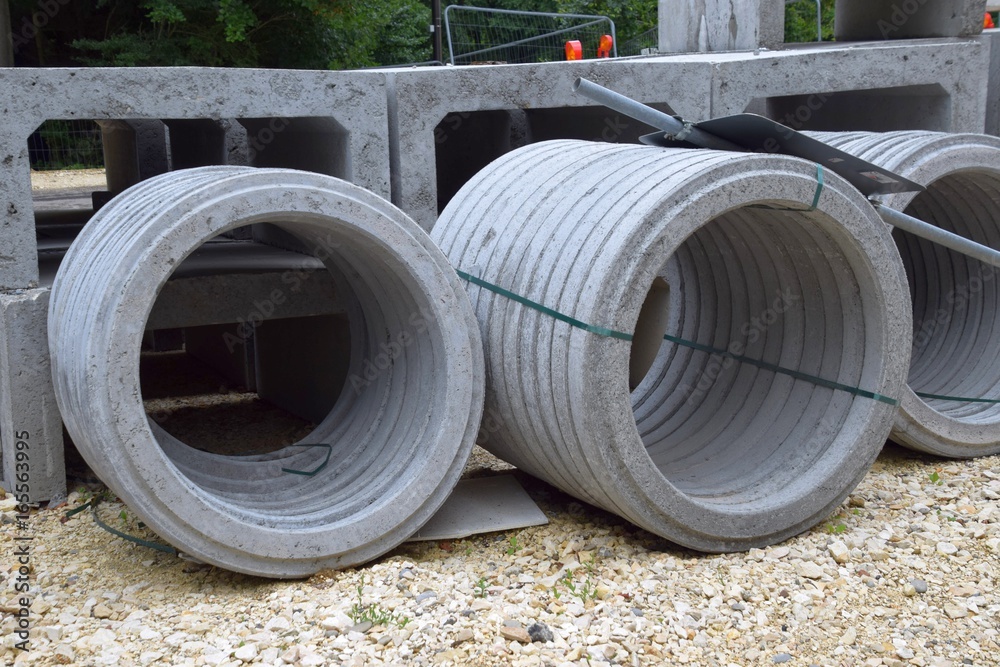 Baustelle mit Baggerschaufel und Betonringe Baustelle mit Baggerschaufel und Betonringe