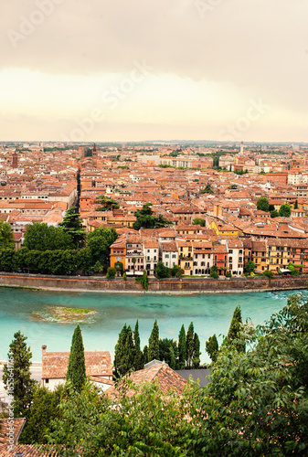Panoramic view to City of Verona with river at sunny day at sunset. Veneto region, Italy. Sunny summer day panorama, sky with clouds and famous european italian terracotta color houses, bird view.