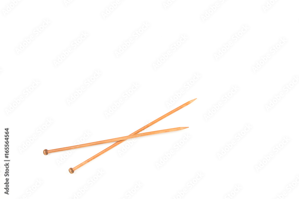 A pair of wooden knitting needles on white background. A pair of wooden knitting needles on white background.