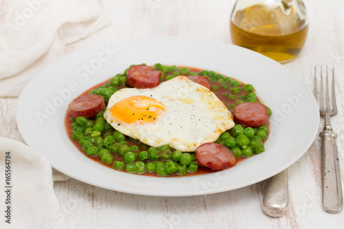 peas with smoked sausage and fried egg on plate