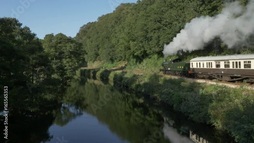 Steam Train Passing By River In British Countryside Aerial 2