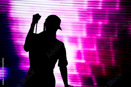 Silhouette of an artist singing live on the stage