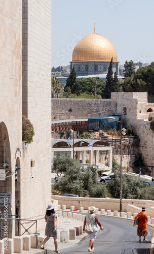 Tourists are walking along the Ma'ale HaShalom Street in the direction of the Al-Aqsa Mosque in the Old City of Jerusalem, Israel photo