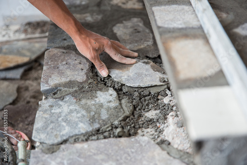 worker installing rock tile