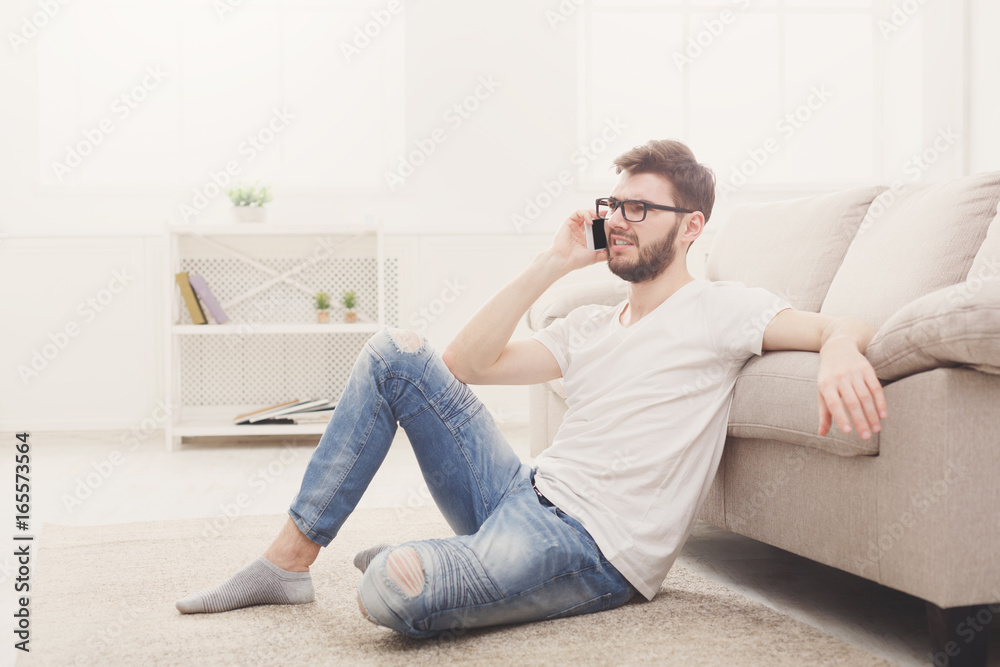 Man in glasses at home with mobile