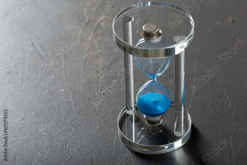 Time is passing. Blue hourglass close up