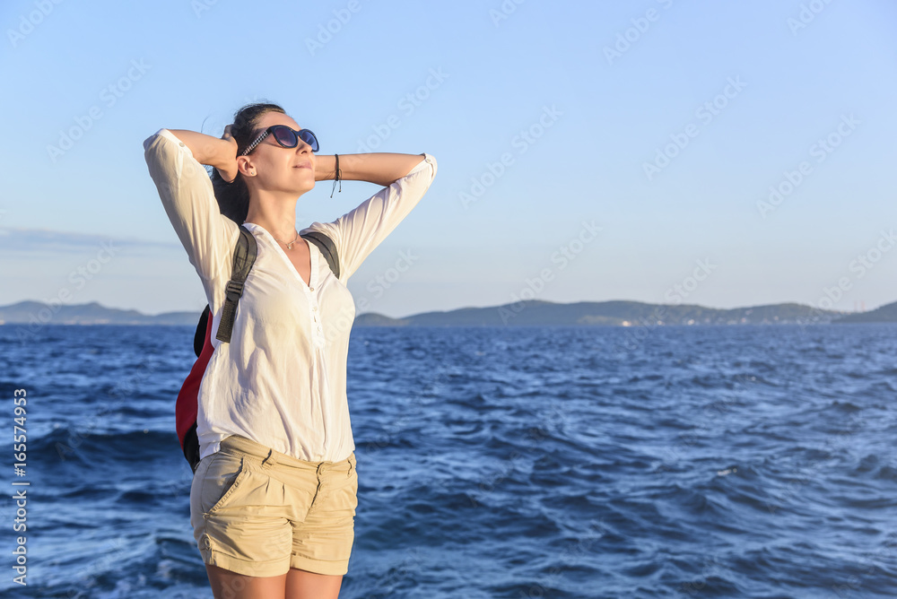 Young woman on the beach at sunset.