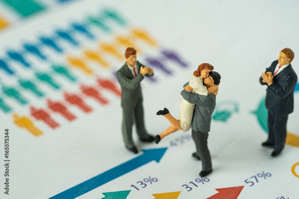 Miniature people with couple standing on printed gender report as couple life style analysis concept Miniature people with couple standing on printed gender report as couple life style analysis concept
