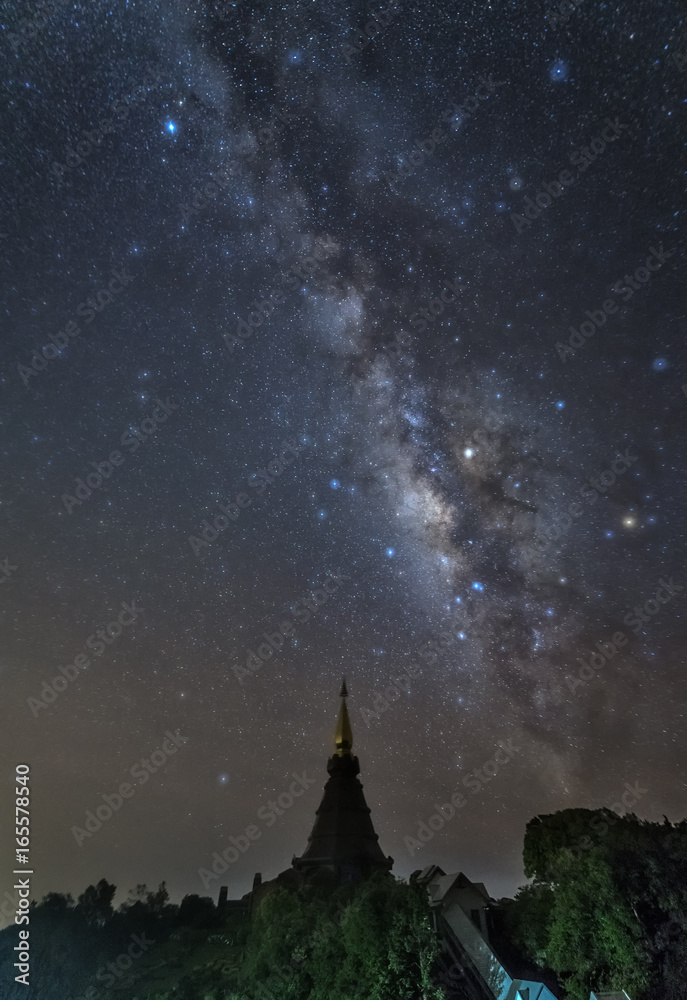 Naklejka premium milky way in starry night with pagoda on top of inthanon national park mountain at Chiang Mai, Thailand