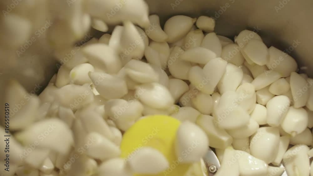 Falling peeled garlic into blander. 4Ksuper slow Falling peeled garlic into blander. 4Ksuper slow