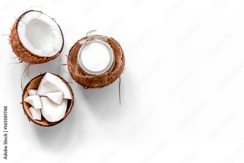 Body treatment. Coconut oil on white background top view copyspace Body treatment. Coconut oil on white background top view copyspace