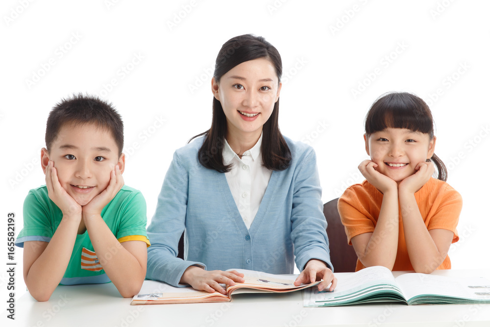 Female teacher helping students study in classroom Female teacher helping students study in classroom