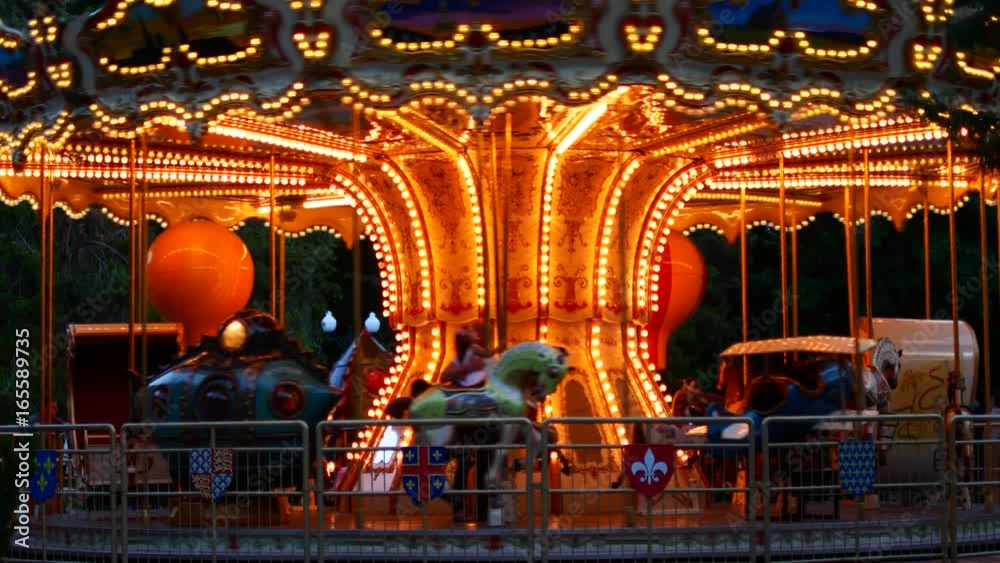 The French carousel is spinning and glowing with lights