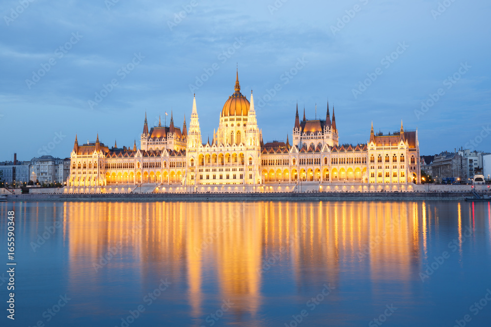 Fototapeta premium The building of Parliament with reflection in the river in Budapest at sunset