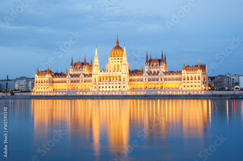 The building of Parliament with reflection in the river in Budapest at sunset