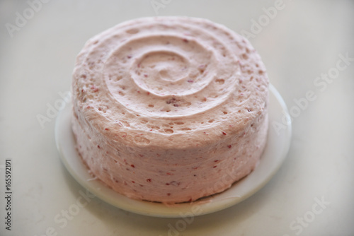 Whole cake with pink swirled frosting 