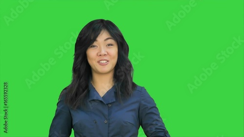 Positive asian businesswoman talking, looking at camera on a Green Screen, Chroma Key