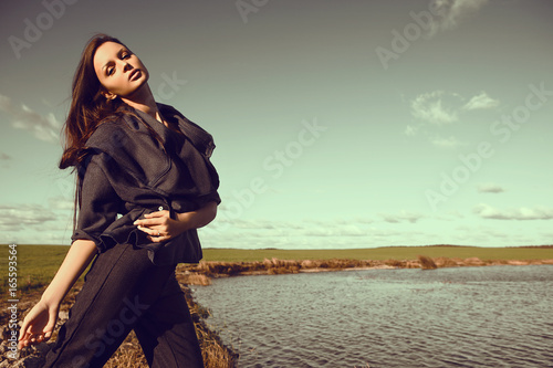 Outdoors portrait of a fashionable young brunette woman posing.