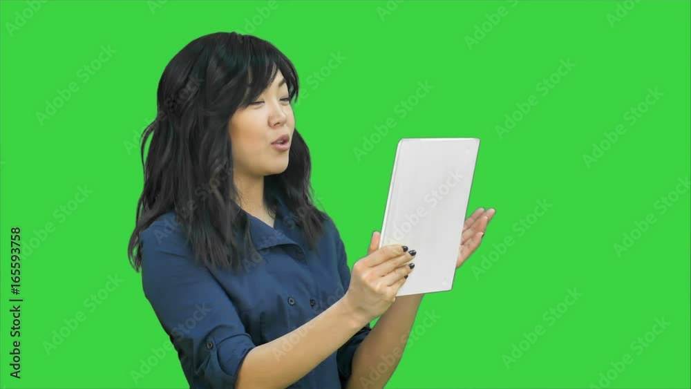 Asian business lady chatting using a tablet on a Green Screen, Chroma Key Asian business lady chatting using a tablet on a Green Screen, Chroma Key