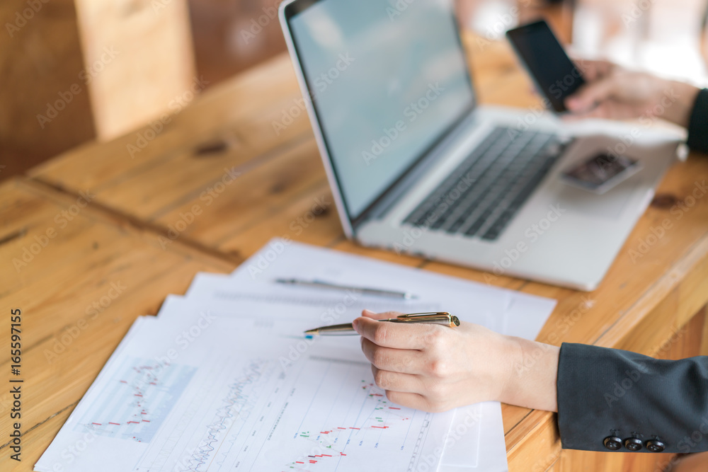 Business woman hand with Financial charts and laptop on the table . Business woman hand with Financial charts and laptop on the table .