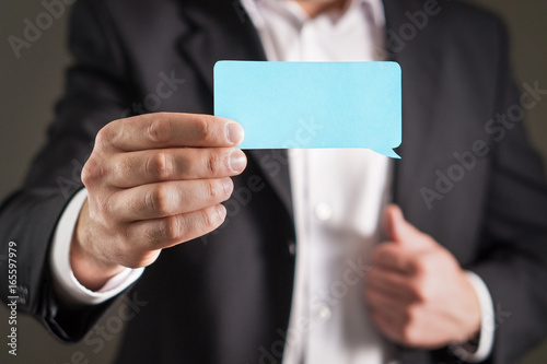 Business man holding speech bubble business card.